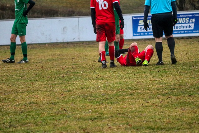 poraněný fotbalista leží na trávníku